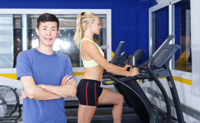 Confident trainer posing at gym