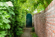 Narrow Access Path To A Wooden Garden Gate