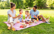 © Syda Productions - family, leisure and people concept - happy mother, father and two little sons having picnic and eating watermelon at summer park