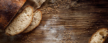 Bread,  Traditional Sourdough Bread Cut Into Slices On A Rustic Wooden Background, Close-up, Top View, Copy Space. Concept Of Traditional Leavened Bread Baking Methods
