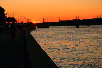 Wall Mural - the setting sun over the bridge in the city across the river