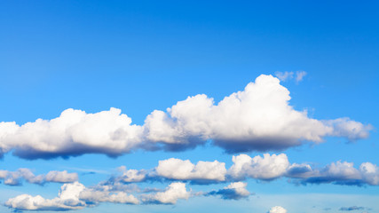 Wall Mural - chains of clouds in blue sky in summer evening