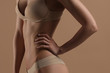 © Mirrorstudio - Thin young woman in underwear on beige background