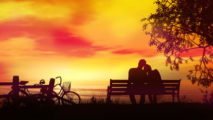 Wall Mural - Couple on a bench watching the evening ocean after a bike ride