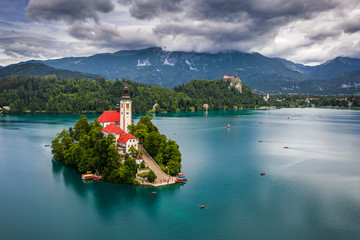 Wall Mural - Bled, Slovenia - Aerial view of beautiful Lake Bled (Blejsko Jezero) with the Pilgrimage Church of the Assumption of Maria and Bled Castle and Julian Alps at backgroud on a cloudy summer day