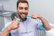 © LIGHTFIELD STUDIOS - handsome bearded man showing thumb up while holding toothbrush