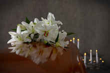 Wooden Casket With White Lilies In Funeral Home, Closeup