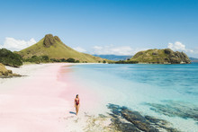 Woman Walking And Enjoying Empty Paradise Tropical Beach With Mountain View. Nobody Around. Aerial View Of Padar Island Pink Beach. Panoramic Photo.