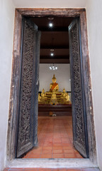 Wall Mural - Beautiful old wooden door frame with Buddha sculpture in Wat Dhamma Racha temple Ayutthaya,Thailand