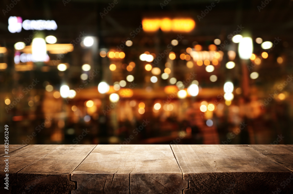 background Image of wooden table in front of abstract blurred restaurant lights - obrazy, fototapety, plakaty 