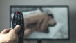 Leinwanddruck Bild - Hand holding TV remote controller. Watching porn