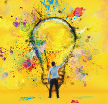 Boy Draws With A Brush A Big Light Bulb. Concept Of Innovation And Creativity. Yellow Style