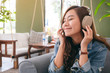 © Farknot Architect - A beautiful asian woman enjoy listening to music with headphone with feeling happy and relaxed in cafe