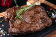 Fried meat steak on slate on a black background