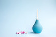 Blue douche and tablets of pink and white color on a blue background. Medical concept.