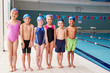 © Monkey Business - Portrait Of Children Standing On Edge Of Pool Waiting For Swimming Lesson