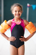© Monkey Business - Portrait Of Girl Wearing Armbands Standing By Edge Of Swimming Pool Ready For Lesson