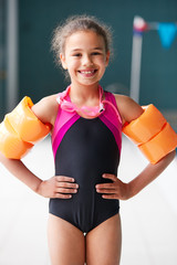 Wall Mural - Portrait Of Girl Wearing Armbands Standing By Edge Of Swimming Pool Ready For Lesson