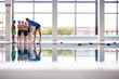 © Monkey Business - Female Coach Giving Children In Swimming Class Briefing As They Sit On Edge Of Indoor Pool