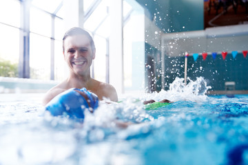 Wall Mural - Male Swimming Coach Giving Boy Learning Backstroke One To One Lesson In Pool