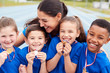 © Monkey Business - Children With Female Coach Showing Off Winners Medals On Sports Day