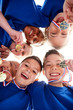 © Monkey Business - Low Angle View Looking Up Into Faces Of Children In Huddle On Sports Day