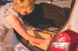 © Mihail - woman putting paper bags with food in car trunk