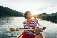 Couple Enjoy Canoeing On Sunset Lake