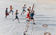 © gstockstudio - Full length top view of young people in sports clothing jogging while exercising outdoors