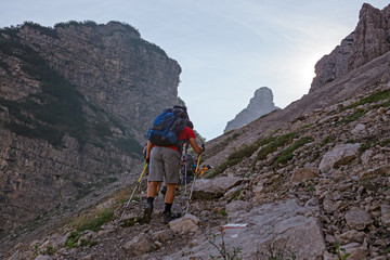 Wall Mural - some hikers go up a steep rocky mountain path.