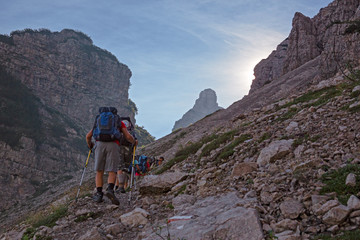 Wall Mural - some hikers go up a steep rocky mountain path.