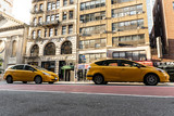 Fototapeta  - Yellow cars near city buildings