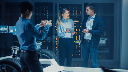 Poster - Automotive Design Engineer and Scientist with Tablet Discuss the Electric Car Chassis Prototype. In Innovation Laboratory Facility Concept Vehicle Frame Includes Wheels, Suspension, Engine and Battery