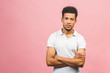 © denis_vermenko - A young serious African American male isolated against pink background.