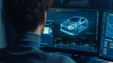 Professional Automotive Graphic Designer Is Working On 3D CAD Software Rendering Electric Concept Car And Calculating Its Efficiency In A High Tech Innovative Laboratory With A Prototype.