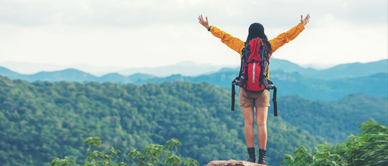 women hiker or traveler with backpack adventure feeling victorious facing on the mountain, outdoor f