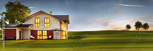 Fotografía Evening view of a modern house with a lawn and a terrace.