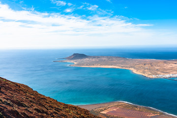 Wall Mural - Unique panoramic magnificent aerial view of volcano cone at volcanic island La Graciosa south coast, in Atlantic ocean, from Mirador del Rio, Lanzarote, Canary Islands, Spain. Travel concept.