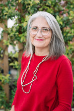 Portrait Of Smiling Senior Woman With Grey Hair Wearing Red Pullover And Glasses