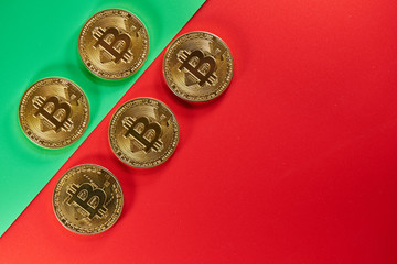 Physical golden coins bitcoins on a red green background. Digital cryptocurrency concept