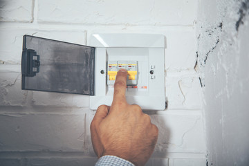 man hand turning off fuse box