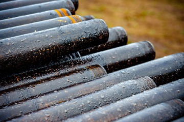 Oil Drill pipe. Rusty drill pipes were drilled in the well section. Downhole drilling rig. Laying the pipe on the deck. View of the shell of drill pipes laid in courtyard of the oil and gas warehouse