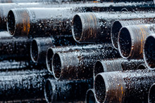 Oil Drill Pipe. Rusty Drill Pipes Were Drilled In The Well Section. Downhole Drilling Rig. Laying The Pipe On The Deck. View Of The Shell Of Drill Pipes Laid In Courtyard Of The Oil And Gas Warehouse