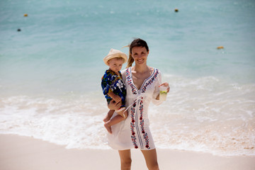 Sticker - Mother and child playing at tropical beach. Family sea summer vacation. Mom and kid, toddler boy, play in the water. Ocean and water fun for parent and kids