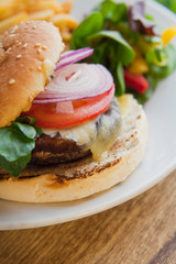 Wall Mural - American style Vegan Portobello Chestnut Mushroom Burger served with tomato,onion, fries and green, fresh salad.