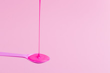 Pink Neon Paint Flows Onto A Pink Spoon.