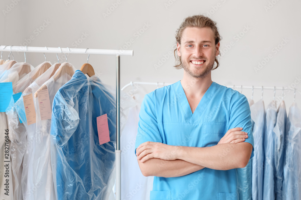 Handsome male worker in modern dry-cleaner's