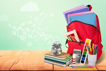 Sticker - Colorful school supplies  in backpack on blackboard background