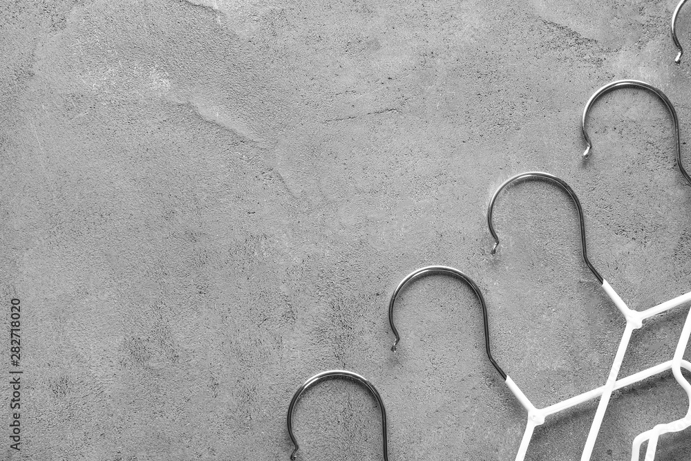 Many clothes hangers on grey background