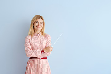 Poster - Beautiful female teacher with pointer on color background